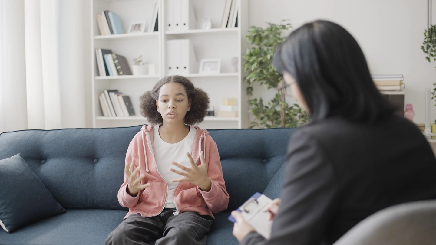 Young girl talking through issues with her therapist.
