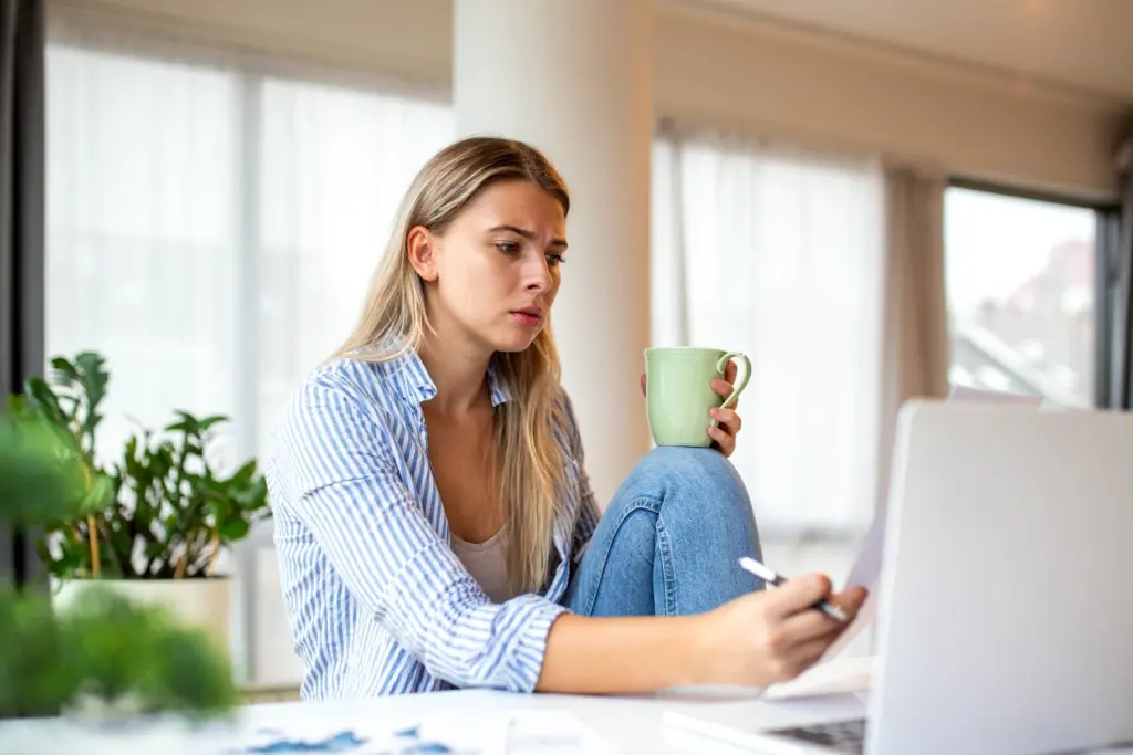 A person sitting alone at a desk surrounded by work and tasks, looking exhausted and overwhelmed, representing the emotional toll of always being the responsible one