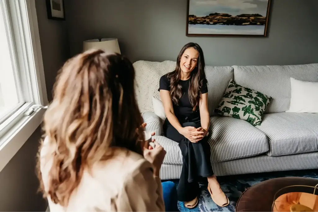 How to Find a Therapist: A Guide to Finding the Right Therapist in Austin 1 Client sitting on a sofa listening attentively during a conversation with her therapist.