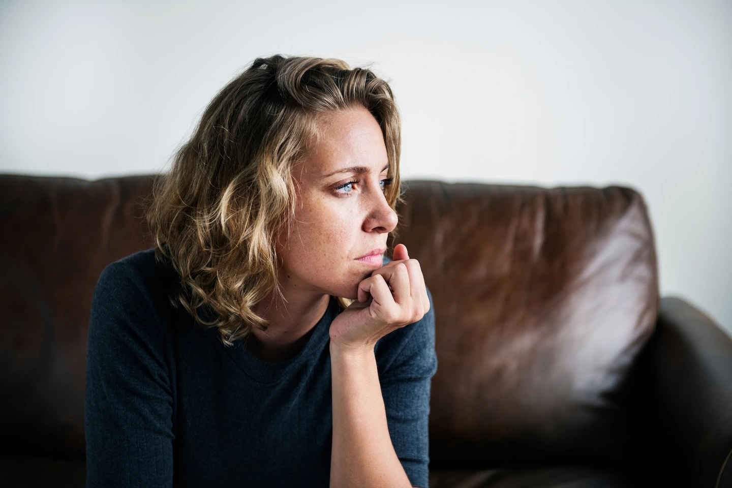 Depression Therapy in Austin: Recognizing the Signs and Knowing When to Get Help 2 Woman sitting on a couch, lost in thought